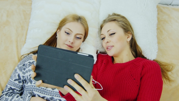Two Young Women Talking With The Tablet