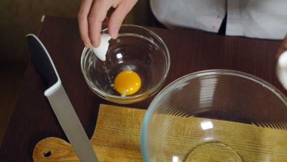 Egg Falling In Glass Bowl. Preparing Ingredients For Baking Cake. Cooking Food