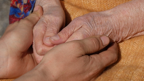 A Young Dirty Working Male Hands Comforting An Elderly Pair Of Hands Of Grandmother