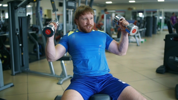 Athletic Man Doing Exercises In a Gym