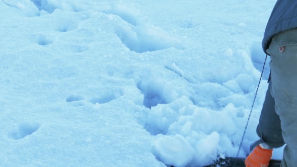 Man Cleaning Snow From Pavement