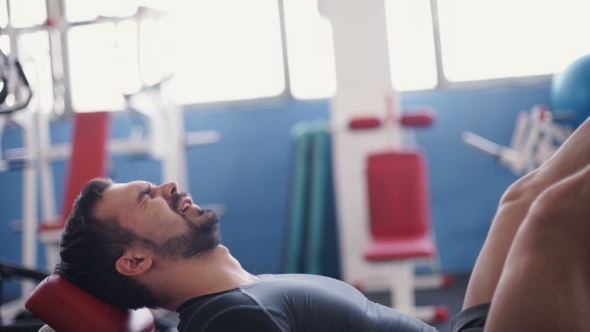 Man Exercising On Leg Press Machine