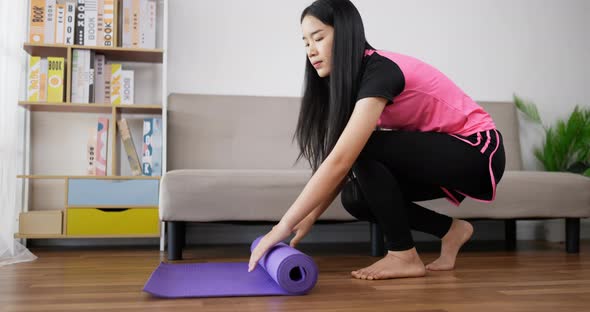 woman rolling up yoga mat