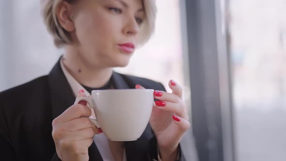 The Woman Works with a Laptop in a Cafe