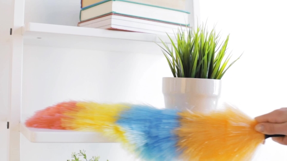 Woman With Duster Cleaning Dust From Shelf At Home 108