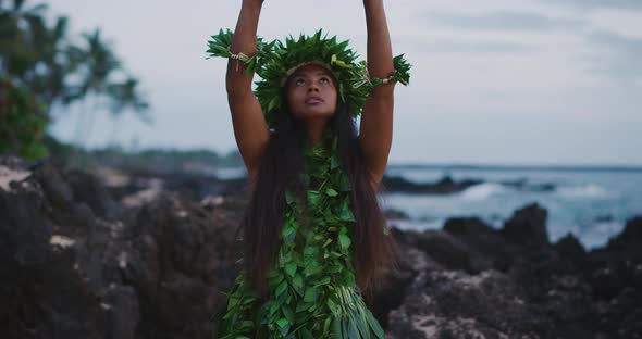 Woman performing traditional Hawaiian hula by the ocean alt
