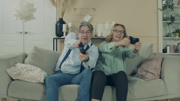 Aged Man and Woman Are Playing a Videogame