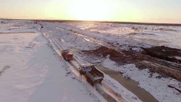 Aerial Sunset View Of Vehicles Convoy Driving On Snow-covered Winter Road