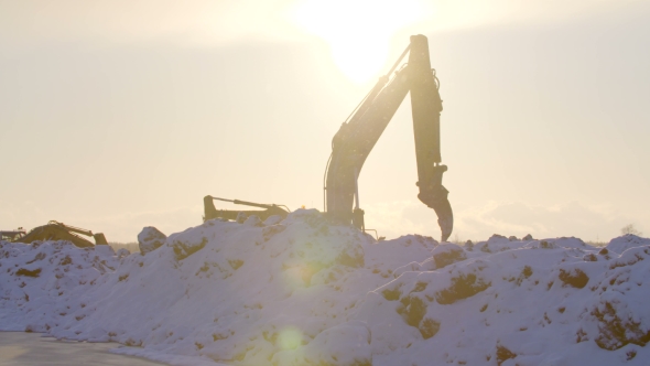Excavators Digging The Ground In Winter Sunset