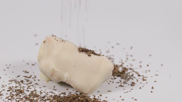 Brown spices falling onto white counter top. Flakes off spice scattered.