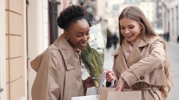 Two Young Women with Shopping Bags Checking What They Bought