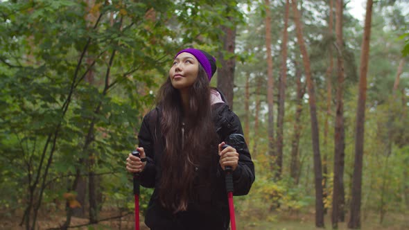 Lovely Asian Woman Backpacking in Autumn Forest