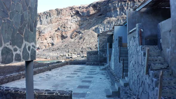 Aerial dolly between the volcanic walls of houses Pozo de Las Calcosas