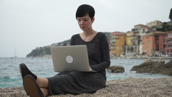 Woman  On The Seaside Working On The Computer.