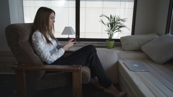 Married Woman Sitting Near The Window Talking On The Phone