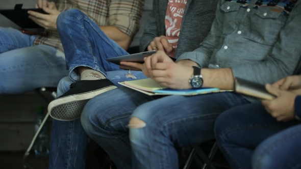 Young People Sitting In a Row, Keep On Their Laps Notebooks, Smartphones And Tablets