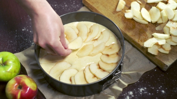 Preparing For Baking Apple Pie. Cook Puts Apple Slices In Baking Dish