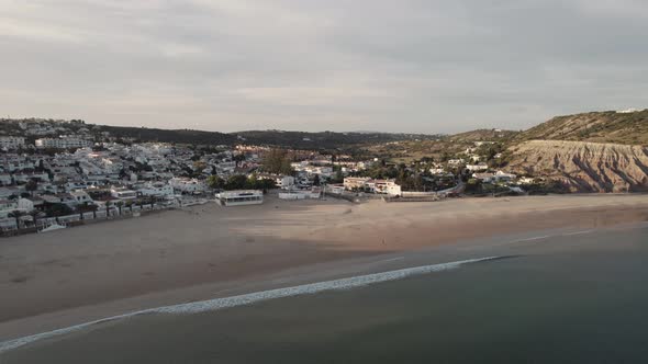 Postcard of Praia da luz shrouded by warm calm sunset, Algarve. Aerial