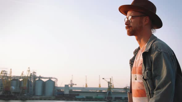 Close Up Shot of Young Stylish Hipster Walking with His Bicycle on Sea Port Background During Sunset