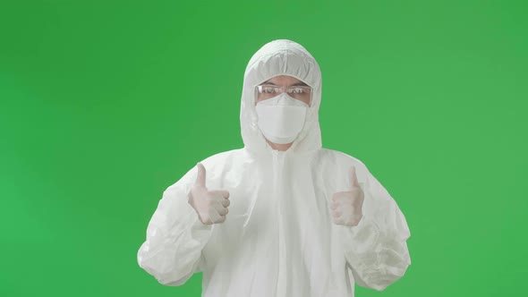 Asian Male Wear Protective Uniform PPE And Showing Thumbs Up In Green Screen Studio