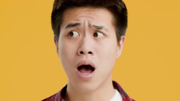 Portrait Of Shocked Asian Man Posing Standing On Yellow Background