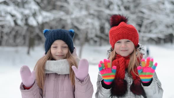 Two Little Sisters Portrait in Winter Gesticulate with Hands Goodbye