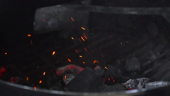 Shifting the charcoal pieces (also called briquettes) of a barbecue in order to improve the cooking,