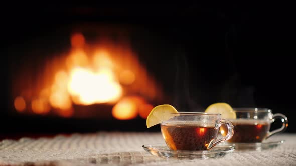 Two Glass Cups of Hot Ow on a Table By the Fireplace