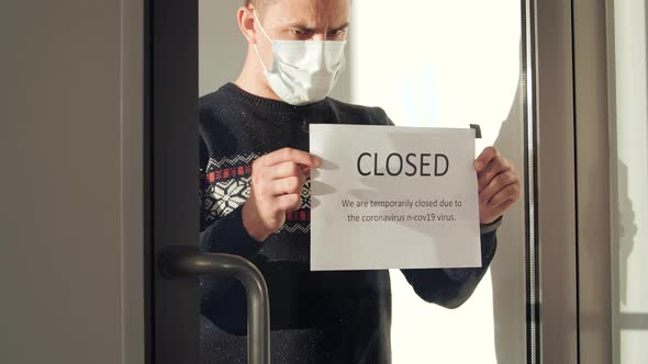 Young Man Hanging Sign Closed Glass Door