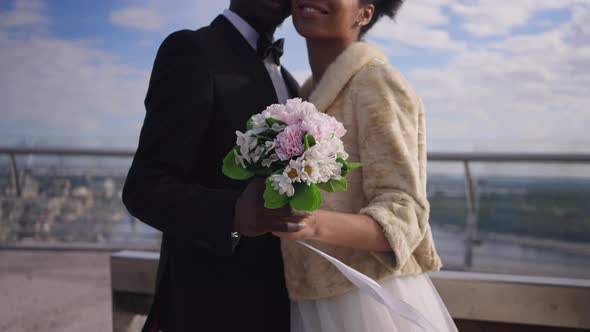 Beautiful Wedding Bouquet in Male and Female Hands with Smiling Unrecognizable African American