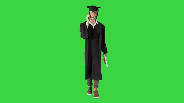 Happy Graduating Student Walking and Making a Call on a Green Screen, Chroma Key