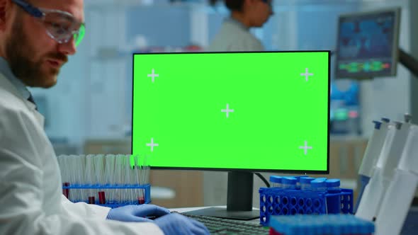 Man Doctor Working at Pc with Green Screen in Modern Equipped Lab