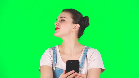 Smiling Girl Talking for Video Chat Using Mobile Phone and Rejoice on Green Screen, Slow Motion