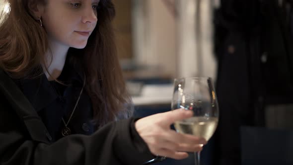 Handheld Middle Shot of Woman with a Phone Drinking Wine