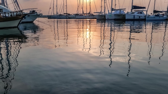 Yachts Masts Reflection In The Sea Water Under The Twilight.