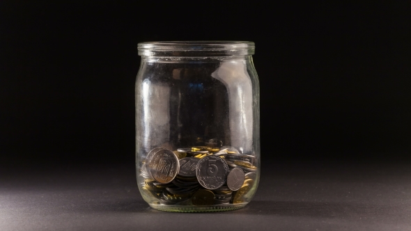 Falling Coins In The Jar On Black Background