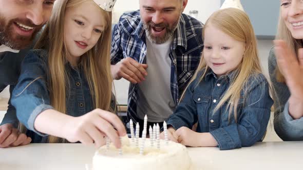 Parents Looking at Girls Putting Candles on Birthday Cake