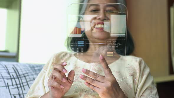 Active Senior Asian Woman Using a Futuristic Tablet