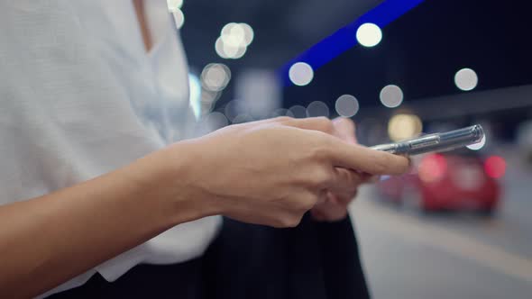 asian business girl stand outside terminal look smart phone check hotel booking wait car at domestic