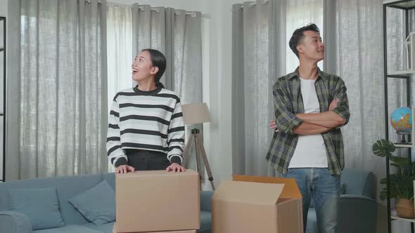 Smiling Young Asian Couple Carrying Cardboard Boxes With Stuff Into A New House