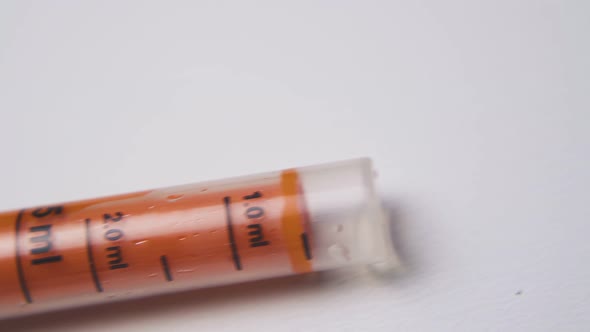 Motion Along Dosage Syringe with Scale on White Background
