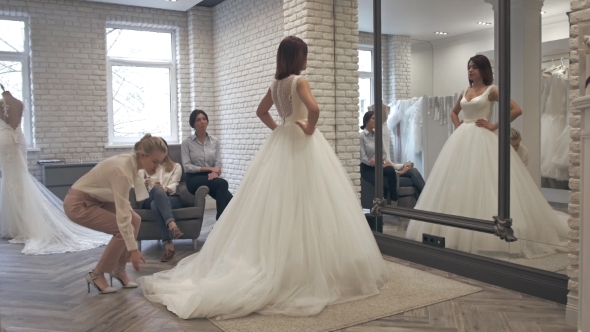 Beautiful Bride At The Clothes Shop For Wedding Dresses, She Is Choosing a Dress With Bridesmaids