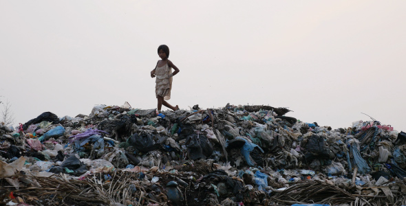 Poor Kid Walking On Mountain Of Garbage 