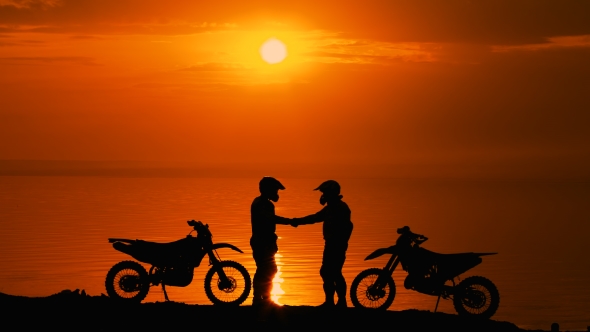 Two Other Motorcyclists Met At River At Sunset. 