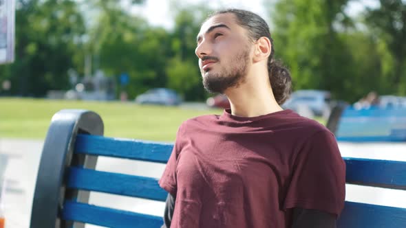 Coseup Portrait of Handsome Arab Man Sitting on a Bench in the Park