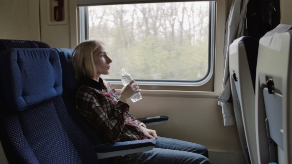 Young Woman Drink Water While Traveling By Train