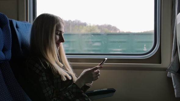 Young Woman Using Smartphone While Traveling By Train