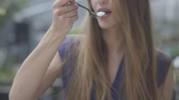 Portrait Beautiful Brunette Woman Eating Cake with a Macaroon in the Restaurant Close Up. Hot Lady