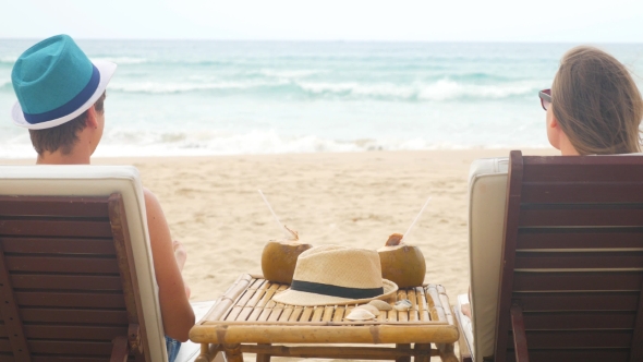 Caucasian Man And Woman In Love Sitting In Beach Chairs