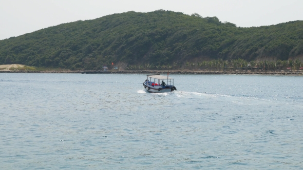 Small Blue Motorboat With Single Person Aboard In See Bay In Vietnam